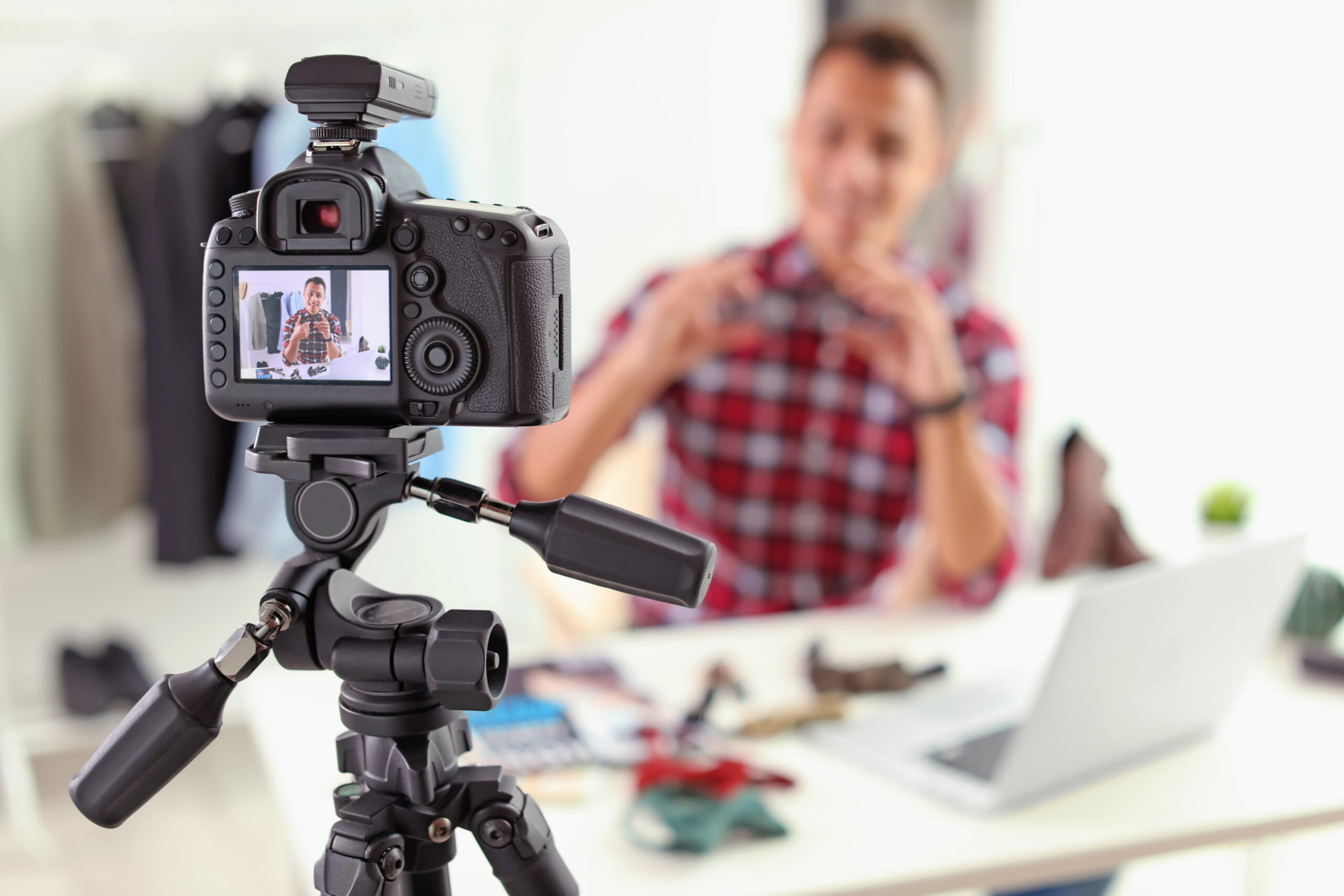 blogger recording video indoors, focus on camera display. Space for text