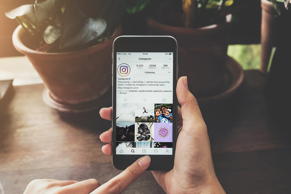 A woman holds Apple iPhone 6S with Instagram application on the screen. Instagram is a photo-sharing app for smartphones.